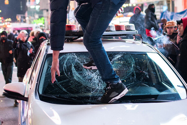 27일(현지시각) 미국 뉴욕에서 흑인 청년 타이어 니컬스 사망 사건에 항의하는 시위대가 경찰차에 올라가 앞유리창을 깨뜨리고 있다. 로이터 연합뉴스