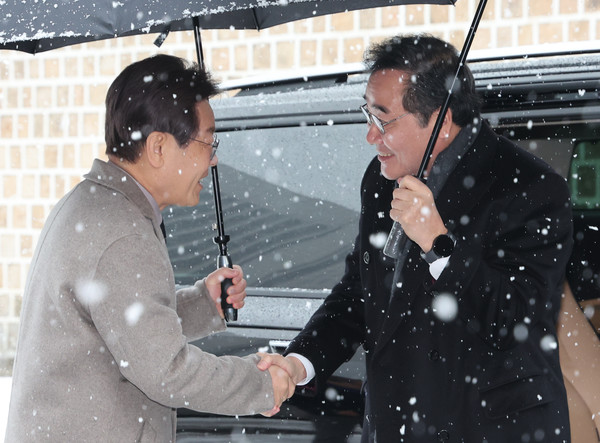 더불어민주당 이재명 대표와 이낙연 전 대표가 30일 오전 서울 중구의 한 식당 앞에서 만나 악수를 하고 있다. 연합뉴스,