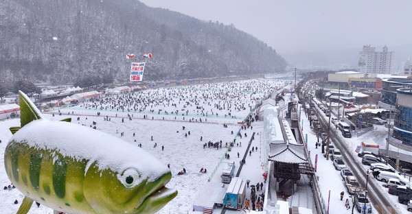 14일 오후 강원 화천군 화천읍 화천천에서 열린 '2024 산천어축제'를 찾은 관광객들이 눈을 맞으며 축제를 즐기고 있다. 연합뉴스