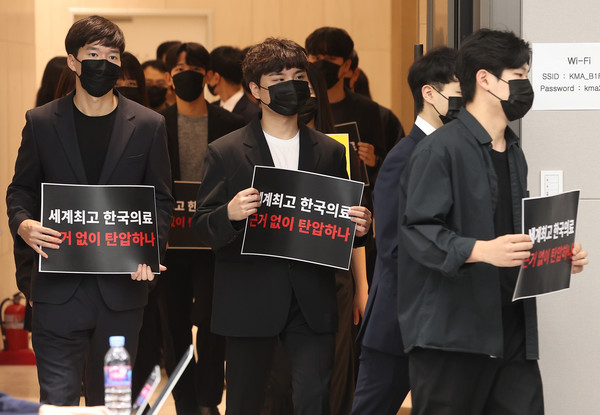 정근영 분당차병원 전공의대표를 포함한 전공의들이 15일 오전 서울 용산구 대한의사협회에서 열린 '정책피해 전공의 박민수 복지부 제2차관 직권남용 및 권리행사방해 혐의 집단고소 기자회견'에서 손팻말을 들고 입장하고 있다. 연합뉴스