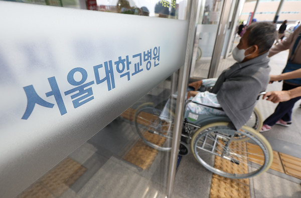 서울의대·서울대병원 교수 비상대책위원회(비대위)는 전공의 사태가 해결되지 않을 경우 오는 17일부터 응급실과 중환자실 등 필수 부서를 제외한 전체 휴진에 들어간다고 6일 밝혔다. 사진은 7일 오전 서울 종로구 서울대학교병원에서 한 환자가 이동하고 있다. 연합뉴스