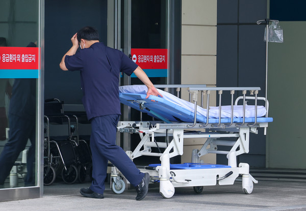 서울의대 교수와 대한의사협회(의협)의 집단휴진 계획 발표에 이어 전국의과대학교수협의회(전의교협) 등이 동참 여부를 논의하기로 하는 등 의정갈등이 격화하고 있는 가운데 11일 오전 서울 시내 한 대형병원에서 한 의료관계자가 머리를 짚은채 응급실로 향하고 있다. 연합뉴스