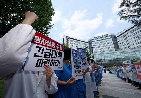 정갈등이 계속되는 가운데 28일 서울 종로구 서울대병원에서 공공운수노조 의료연대 서울대병원 분회 조합원들이 정부에 공공의료 대책 마련과 의사 증원 등을 촉구하는 피켓을 든 채 구호를 외치고 있다. 연합뉴스
