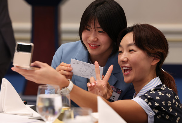 파리올림픽 유도 메달리스트인 허미미(왼쪽)가 14일 청와대 영빈관에서 열린 독립유공자 후손 초청 오찬에서 한 참석자에게 사인해 준 뒤 함께 셀카를 찍고 있다. 연합뉴스