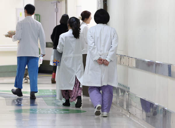 지난해 2월 병원을 떠난 국립대병원 전공의 대다수가 올해 상반기에도 복귀하지 않은 것으로 나타났다. 서울대병원은 사직 전공의를 대상으로 지난 1월 573명의 레지던트를 모집했는데 지원율은 2.8%(16명 지원)에 불과했다. 사진은 이날 서울 종로구 서울대병원에서 의료진이 이동하고 있다.  연합뉴스