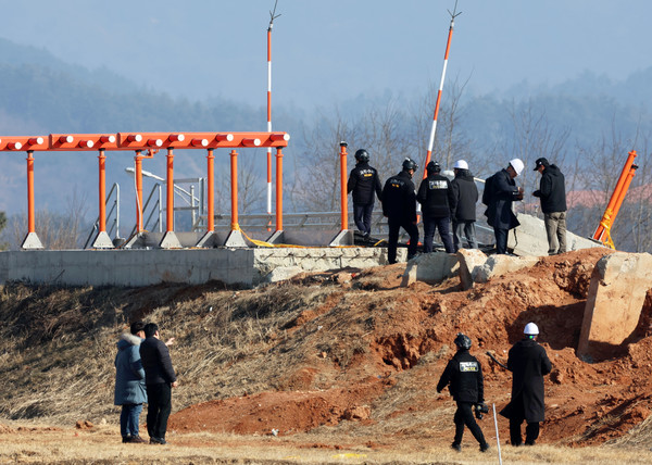 지난달 26일 오후 전남 무안국제공항에서 항공철도사고조사위원회, 경찰, 국과수 관계자들과 제주항공 참사 유가족 대표단이 방위각 시설(로컬라이저)을 살펴보고 있다. 연합뉴스