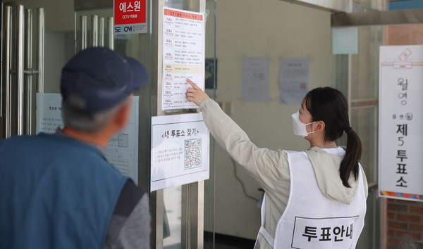 제21대 대통령 선거일인 3일 경남 창원시 마산합포구 해운중학교 1층 체육관에 마련된 월영동 제4·5 투표소 입구에서 한 시민이 투표안내원으로부터 주소지 관할 투표소 위치에 관해 설명 듣고 있다. 연합뉴스