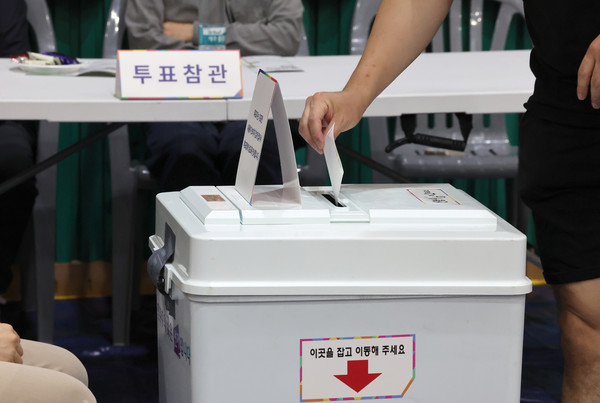 제21대 대통령선거 투표일인 3일 오후 울산 남구 월평초등학교 체육관에 설치된 신정4동 제2투표소에서 투표참관인들이 지켜보는 가운데 한 유권자가 기표를 마친 투표지를 투표함에 넣고 있다. 연합뉴스