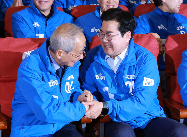 더불어민주당 윤여준, 박찬대 상임총괄선대위원장이 3일 국회의원회관 개표상황실에서 제21대 대통령선거 지상파 출구조사 결과에서 이재명 후보가 51.7%로 앞서는 것으로 발표되자 기뻐하며 악수하고 있다. 연합뉴스