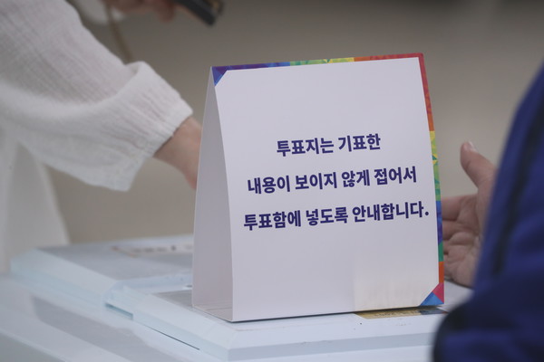 제21대 대통령선거 투표일인 3일 오후 울산 남구 월평초등학교 체육관에 설치된 신정4동 제2투표소에서 투표참관인들이 지켜보는 가운데 한 유권자가 기표를 마친 투표지를 투표함에 넣고 있다. 연합뉴스