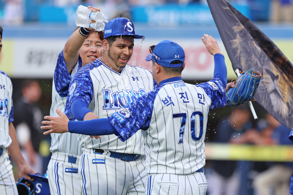 8일 NC전서 완봉승을 거둔 투수 아리엘 후라도(가운데)가 박진만 감독과 동료들의 축하를 받고 있다. 삼성라이온즈 제공