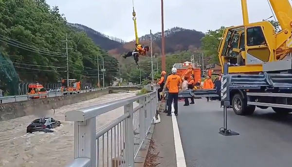 14일 구조대원이 청송군 청송읍 부곡리 한 하천에 빠진 차량에 고립된 시민을 구조하고 있다. 경북소방본부 제공