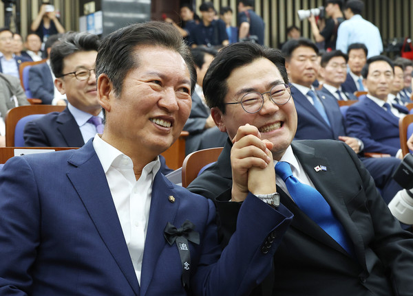 더불어민주당 당대표 후보인 정청래(왼쪽)·박찬대 의원이 24일 서울 여의도 국회에서 열린 의원총회에 참석해 손잡고 있다. 연합뉴스