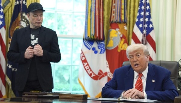 지난 5월 30일(현진시간)미국 백악관에서 일론 머스크(왼쪽) 테슬라 최고경영자가 책상에 앉아 발언하는 도널드 트럼프 대통령을 바라보고 있다. AP 연합뉴스