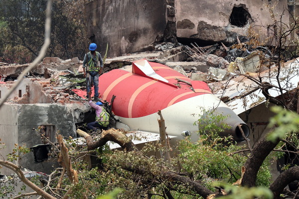14일 인도 서부 구자라트주 아마다바드의 사르다르 발라브바이 파텔 국제공항 인근 추락 현장에서 관계자들이 에어인디아 여객기의 잔해를 조사하고 있다. EPA연합뉴스
