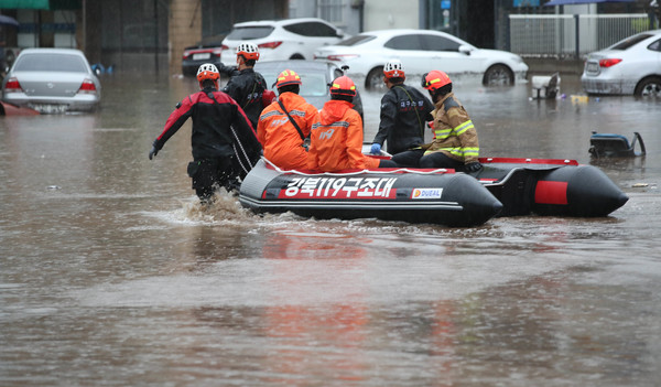  17일 오후 대구 북구 노곡동에서 119구조대가 보트를 타고 인명 수색을 하고 있다. 이날 갑작스러운 폭우로 노곡동 일대가 물에 잠겨있다.  연합뉴스