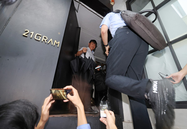 김건희 여사의 각종 의혹을 수사하는 민중기 특별검사팀 수사관들이 13일 서울 성동구에 위치한 인테리어 업체 '21그램' 압수수색을 위해 건물로 들어가고 있다. 이날 김건희 특검은 관저 이전과 관련해 21그램 등 관련 회사 및 관련자 주거지 등에 대해 건설산업기본법 위반 등 혐의로 압수수색을 진행하고 있다. 연합뉴스