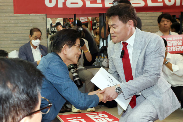 국민의힘 전당대회 합동연설회를 방해해 당 윤리위원회에 회부된 한국사 강사 전한길 씨가 14일 서울 여의도 중앙당사에서 열린 윤리위원회에 참석하기 전 농성중인 김문수 당 대표 후보와 인사하고 있다. 연합뉴스