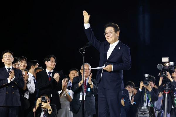  이재명 대통령이 15일 서울 광화문광장에서 열린 제21대 대통령 국민임명식 행사에서 감사 인사를 하며 손을 들어보이고 있다. 연합뉴스
