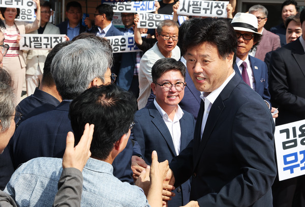 대장동 개발 민간업자 일당에게 금품을 받은 혐의로 항소심에서 실형을 선고받고 법정구속 된 김용 전 민주연구원 부원장이 20일 경기도 화성시 마도면 화성직업훈련교도소에서 보석으로 석방된 후 참석자들과 인사하고 있다. 연합뉴스