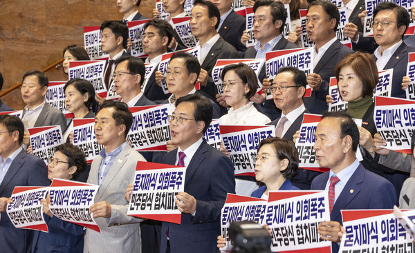 국민의힘 송언석 원내대표를 비롯한 의원들이 27일 국회 본청 계단에서 열린 '묻지마식 의회폭주 민주당식 협치파괴' 규탄대회에서 손팻말을 들고 구호를 외치고 있다. 연합뉴스