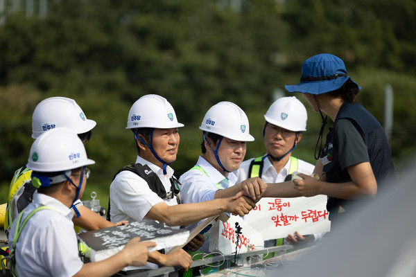 28일 경북 구미시 한국옵티칼하이테크 공장에서 박정혜 수석부지회장(금속노조 한국옵티칼하이테크지회)이 고용승계를 요구하며 599일째 고공농성을 이어가는 가운데 더불어민주당 정청래 대표가 현장을 찾아 얘기를 나누고 있다. 더불어민주당 제공.