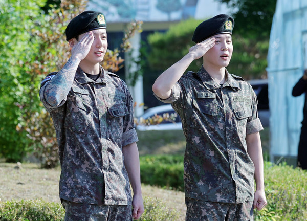 육군 병장으로 만기 전역한 BTS 지민과 정국이 11일 경기 연천군 연천공설운동장에서 열린 기념행사에서 팬들에게 거수경례로 전역 인사하고 있다. 연합뉴스