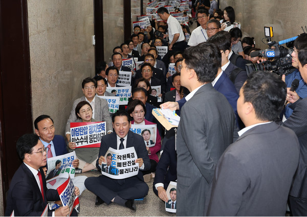 '계엄 해제 표결 방해 의혹'을 수사하는 조은석 내란 특별검사팀의 국민의힘 원내대표실에 대한 압수수색 시도가 이어지고 있는 3일 국민의힘 의원들이 서울 여의도 국회 원내대표실 앞에서 '야당탄압 정치보복 압수수색 중단하라'라고 적힌 손팻말을 들고 농성을 하고 있다. 연합뉴스