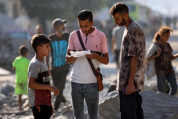 9일(현지시간) 한 남성이 이스라엘 군이 가자 시에 투하한 전단지를 읽고 있다. 해당 전단은 주민들에게 남쪽 알마와시 지역으로 대피하라고 촉구하는 내용이다. AFP 연합뉴스