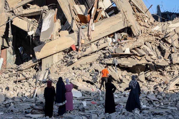 9일(현지시간) 가자 시에서 전날 이스라엘의 공습으로 파괴된 살람 타워 잔해 속에서 사람들이 쓸 만한 물건을 수색하고 있다. AFP 연합뉴스