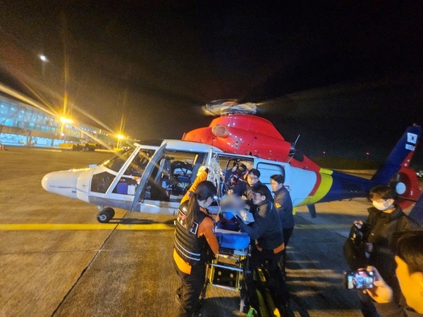 뇌출혈 증세 응급환자를 태운 해경헬기가 포항경주공항에 도착해 환자가 대기 중이던 119구급대에 인계돼고 있다..동해지방해양경찰청 제공.