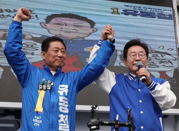 이재명 더불어민주당 대표(오른쪽)가 지난 2024년 총선 당시 부산 수영구에 출마한 유동철 후보의 손을 들어 지지하고 있다. 연합뉴스