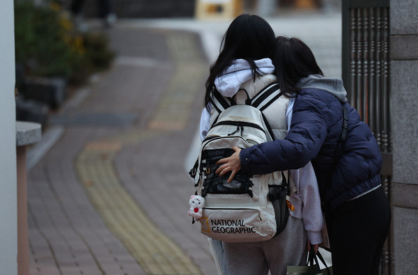 2026학년도 대학수학능력시험(수능)일인 13일 대구 수성구 대구여자고등학교 수능 시험장 앞에서 수험생이 가족의 포옹을 받고 있다. 연합뉴스
