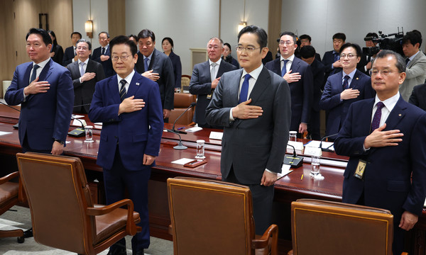 이재명 대통령이 16일 용산 대통령실에서 열린 한미 관세협상 후속 민관 합동회의에서 국기에 경례하고 있다. 연합뉴스
