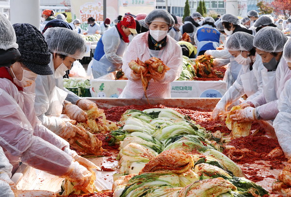 17일 서울 송파구 가락몰에서 열린 '2025 가락시장 김장나눔 시민대축제'에서 참가 상인 및 자원봉사자들이 김치를 담그고 있다. 연합뉴스