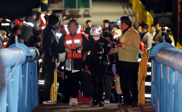 19일 오후 전남 목포시 목포해양경찰서 전용 부두로 여객선 퀸제누비아2호 탑승객들이 구조돼 이동하고 있다. 연합뉴스